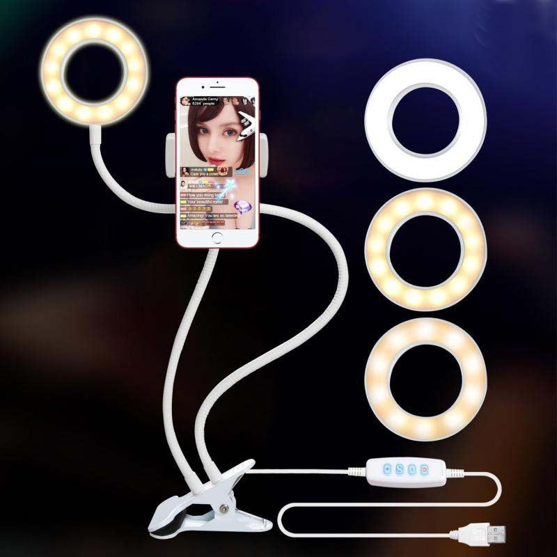 LED ring light with phone holder clamped to a desk